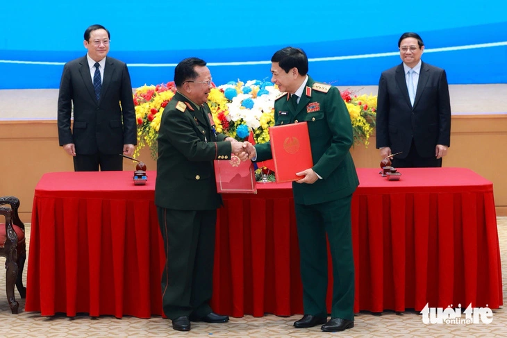 Prime Minister Pham Minh Chinh and Prime Minister Sonexay Siphandone witness the defense minister of Vietnam and Laos exchange cooperation deals in Hanoi on January 6, 2023.