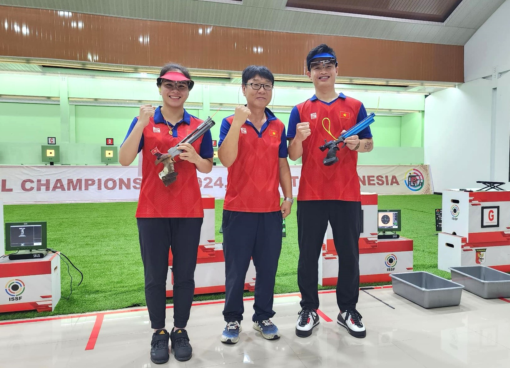 Vietnamese athletes Pham Quang Huy (R) and Trinh Thu Vinh (L) with head coach Park Chung Gun after winning the gold medal in the 10m air pistol mixed team event at the Asian Rifle/Pistol Championship 2024 in Indonesia, January 9, 2024. Photo: Nhung Nguyen / Tuoi Tre