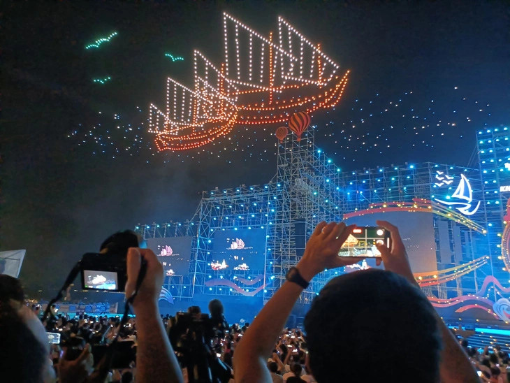 This image shows visitors using their smartphones to photograph one of the drone light performances at the opening ceremony of the Nha Trang - Khanh Hoa Beach Festival 2023 in Nha Trang City on June 3, 2023. Photo: Minh Chien / Tuoi Tre