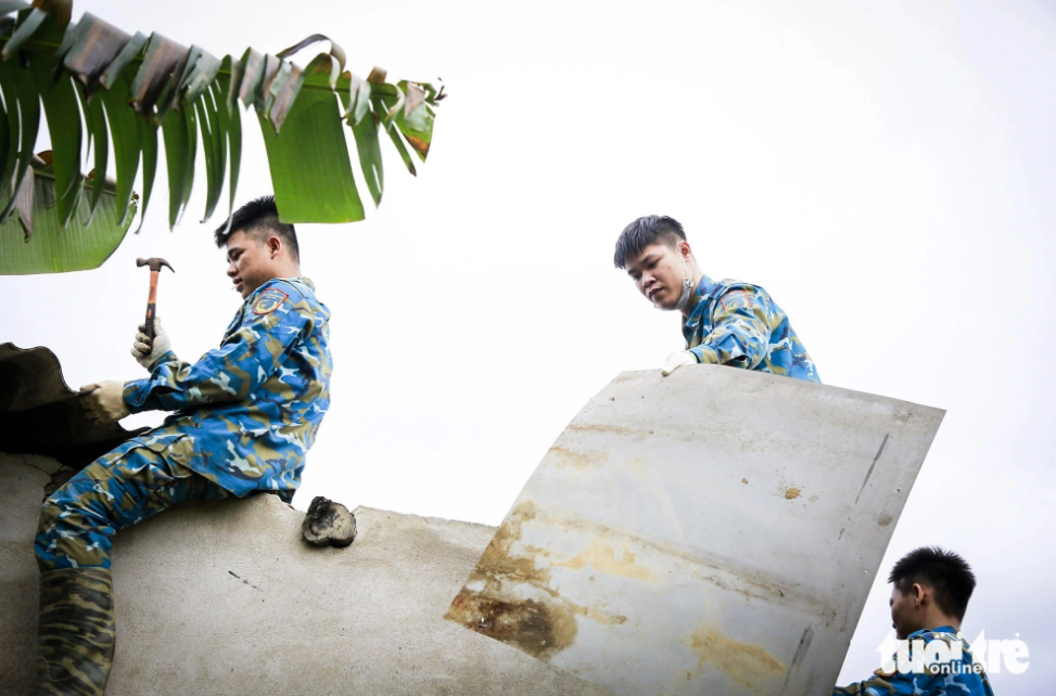 Vietnamese military officers repair houses affected by Russian-made trainer aircraft crash
