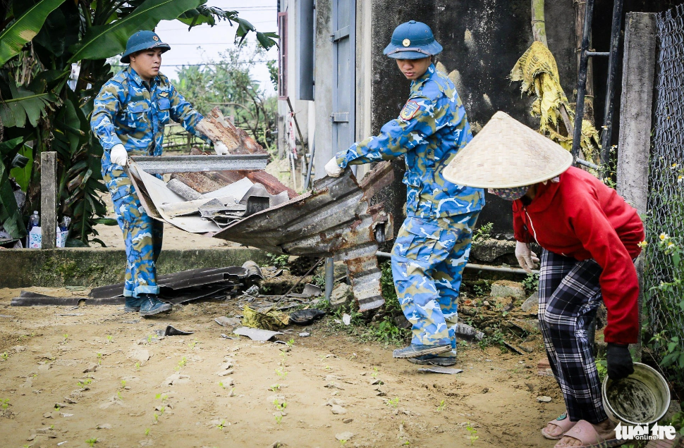 Air force officials replace the damaged metal roofing sheets of a house with the new ones after a military trainer plane crash in Quang Nam Province, central Vietnam. Photo: C.S. / Tuoi Tre