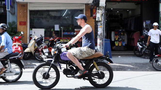 A foreigner rides a motorbike without wearing a crash helmet in Ho Chi Minh City, Vietnam. Photo: Ngoc Duong / Tuoi Tre
