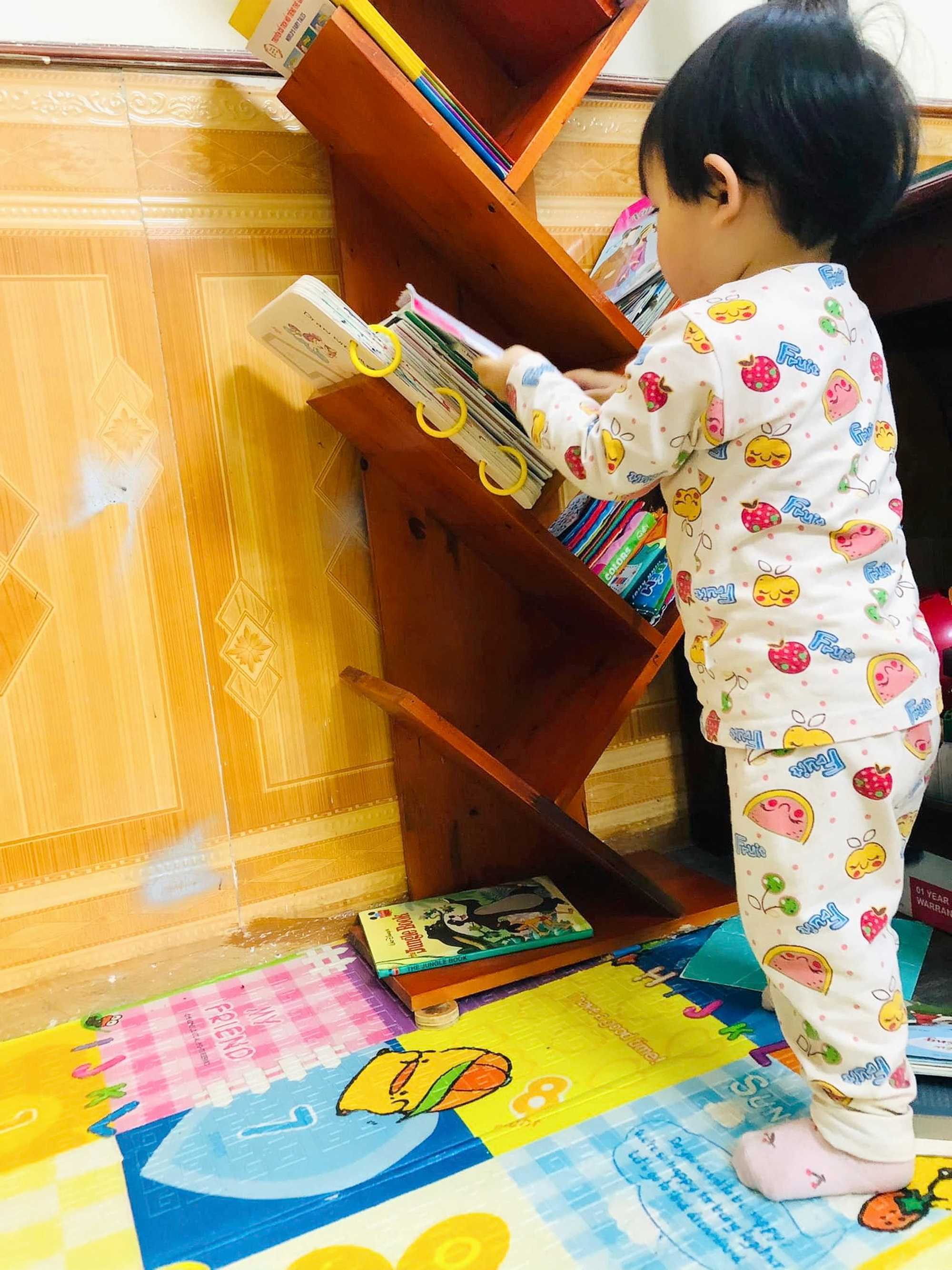 Vu Thuy Nga’s child takes a book from a shelf in their house in Ninh Binh Province, northern Vietnam. Photo: Supplied