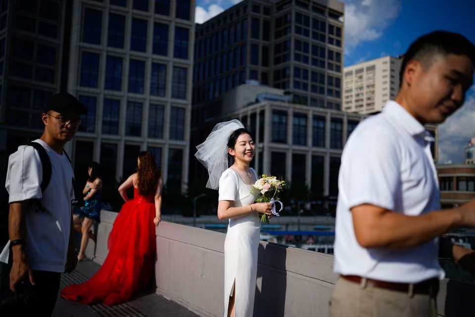 Couples prepare to get their photo taken during a wedding photography shoot on a street, in Shanghai, China September 6, 2023. Photo: Reuters