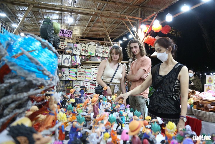 Foreign tourists visit a booth of souvenirs at the fest. Photo: Phuong Quyen / Tuoi Tre