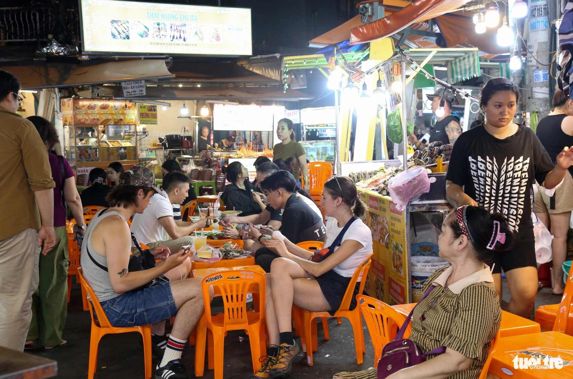 Local and foreign visitors sample food offered at the Ho Thi Ky food street in District 10, Ho Chi Minh City. Photo: Thao Le / Tuoi Tre