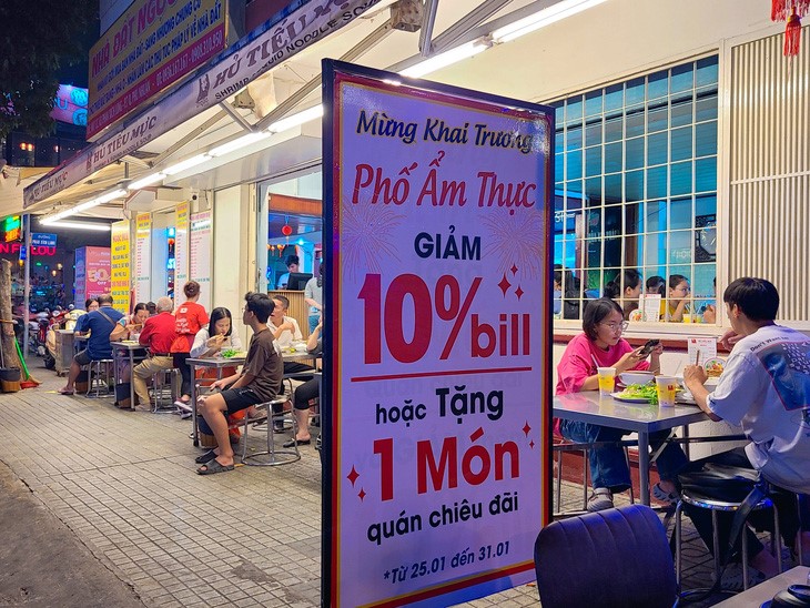 An eatery on Phan Xich Long Food Street offers a 10-percent discount and a dish at no charge for customers in response to the opening of the food street. Photo: Nhat Xuan / Tuoi Tre