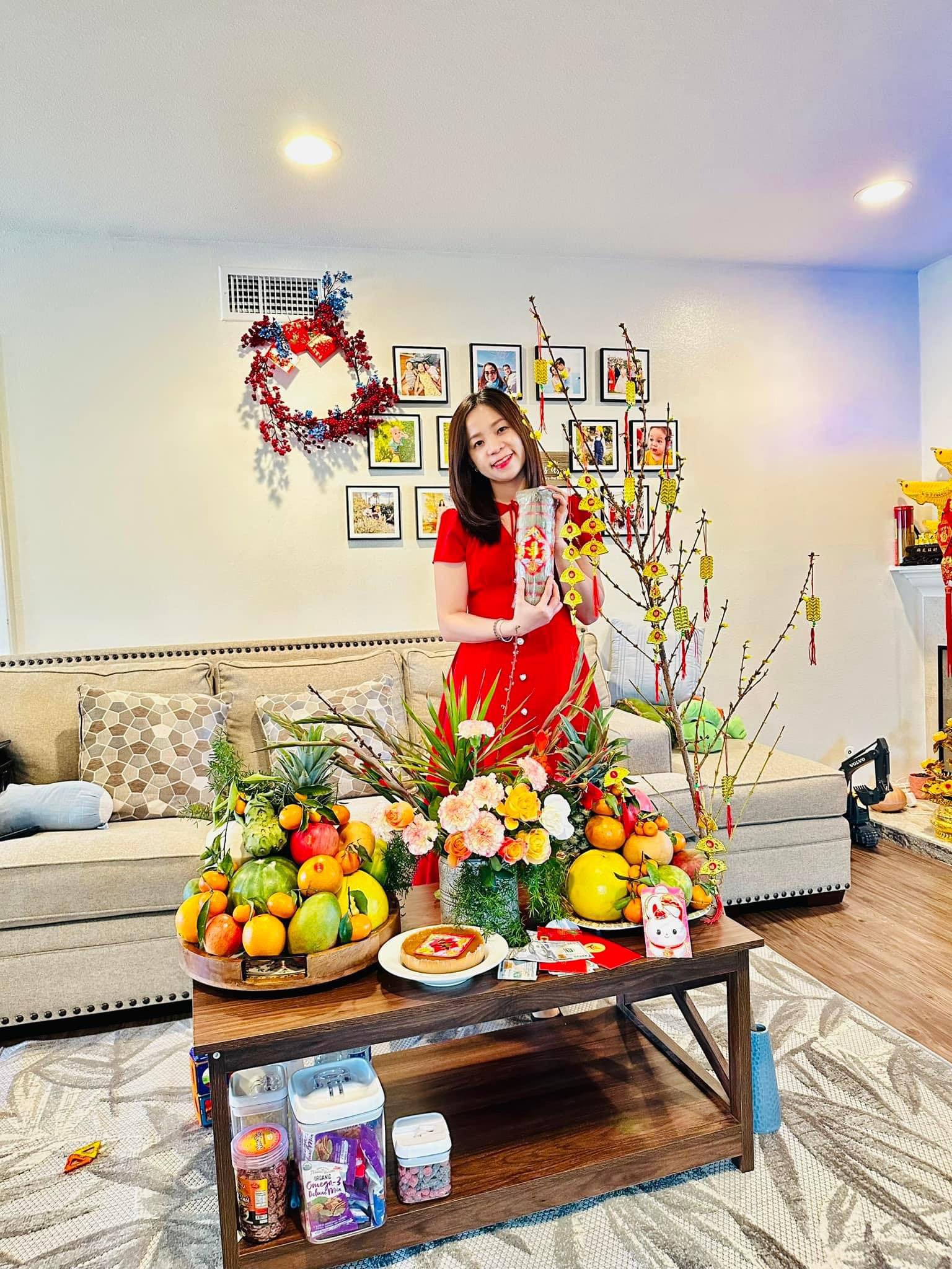 Nguyen Thi Hoang Phu, who lives in the United States with her husband and son, poses for a photo with a fruit tray and flowers for the 2023 Lunar New Year holiday. Photo: Supplied