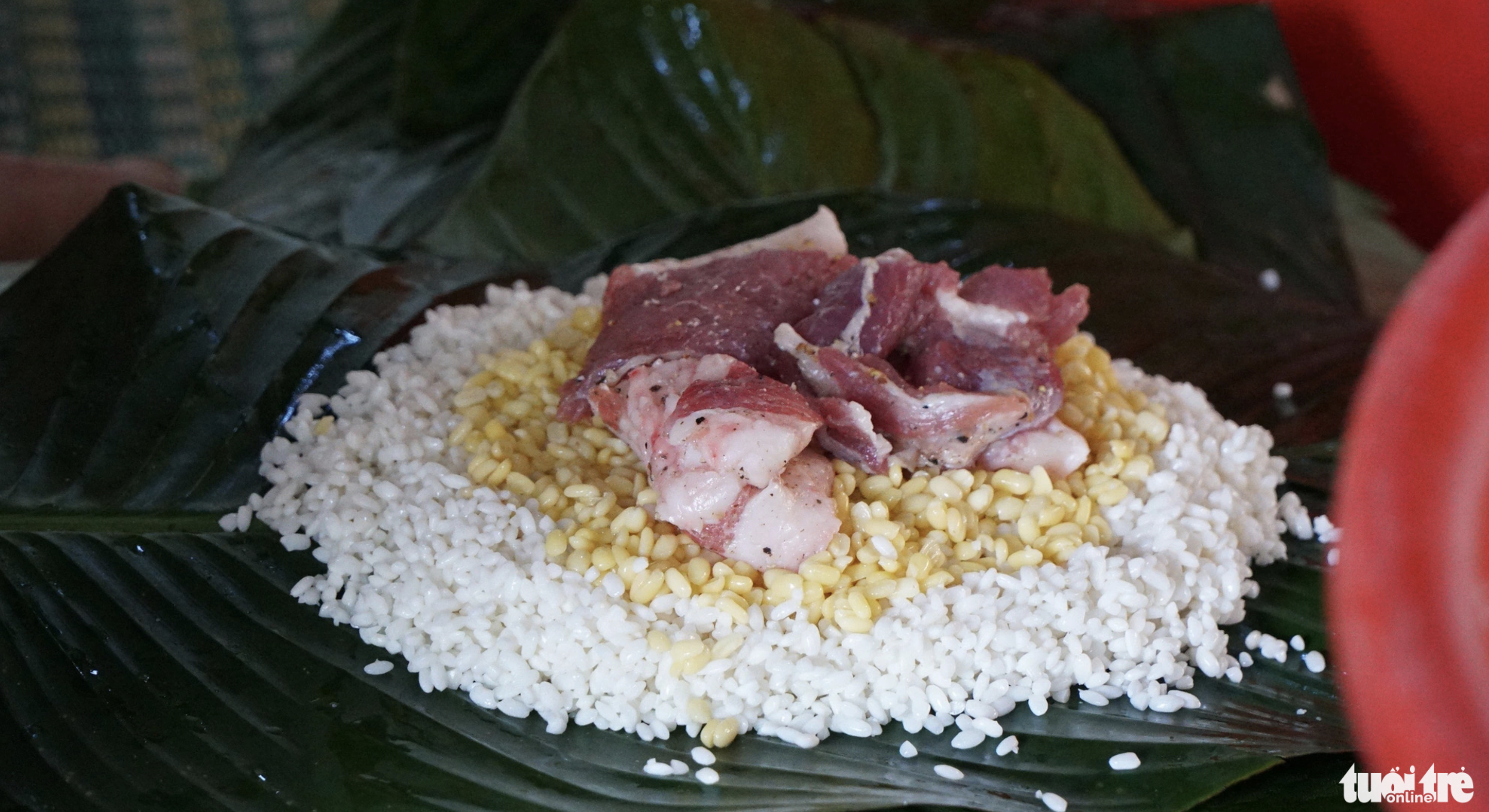 Pork and mung beans are put onto sticky rice to make banh chung. Photo: Tuoi Tre