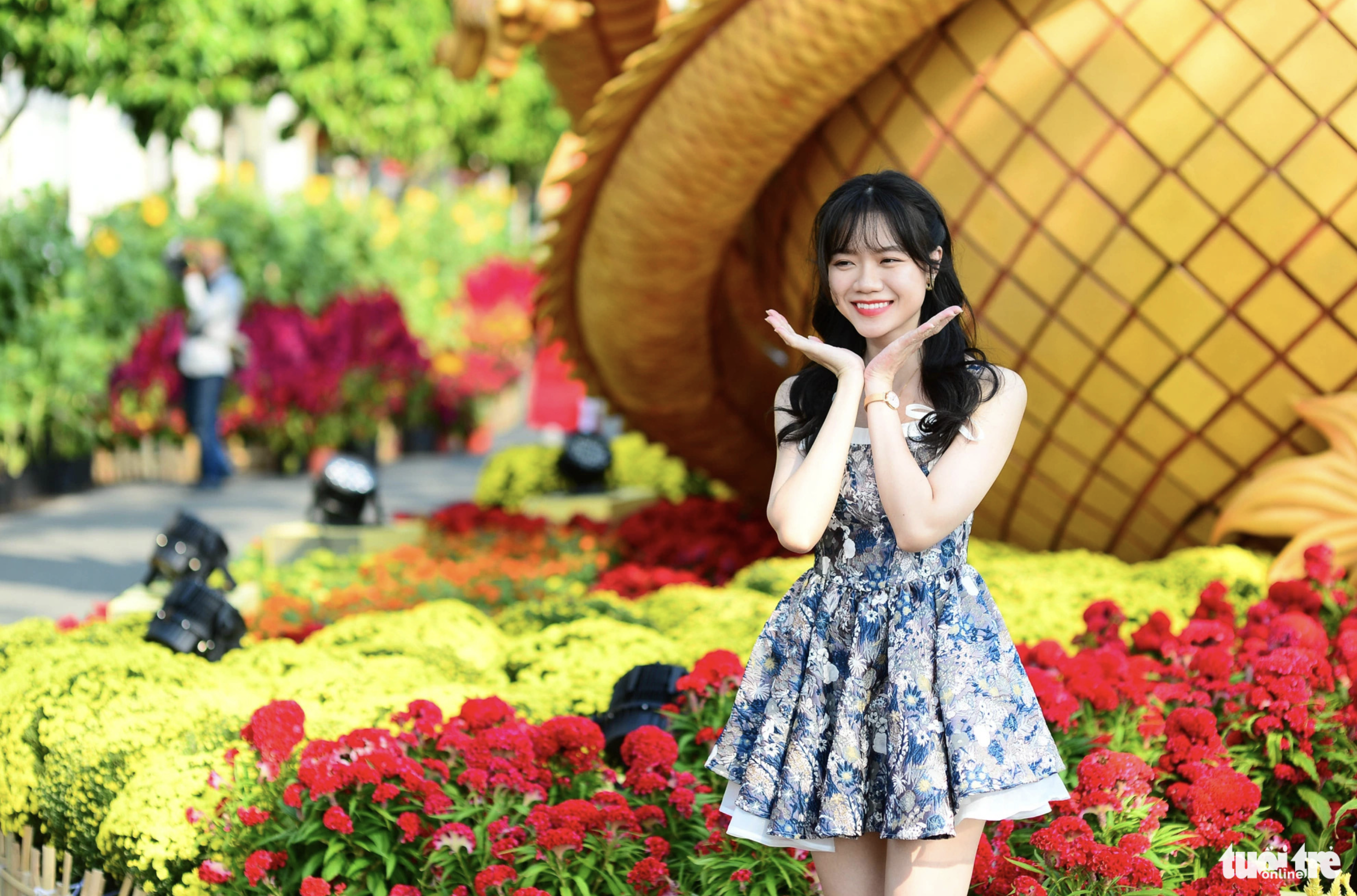 A young woman is eager to pose for a photo on Phu My Hung Flower Street, which opened to the public in Ho Chi Minh City on February 3, 2024. Photo: Quang Dinh / Tuoi Tre