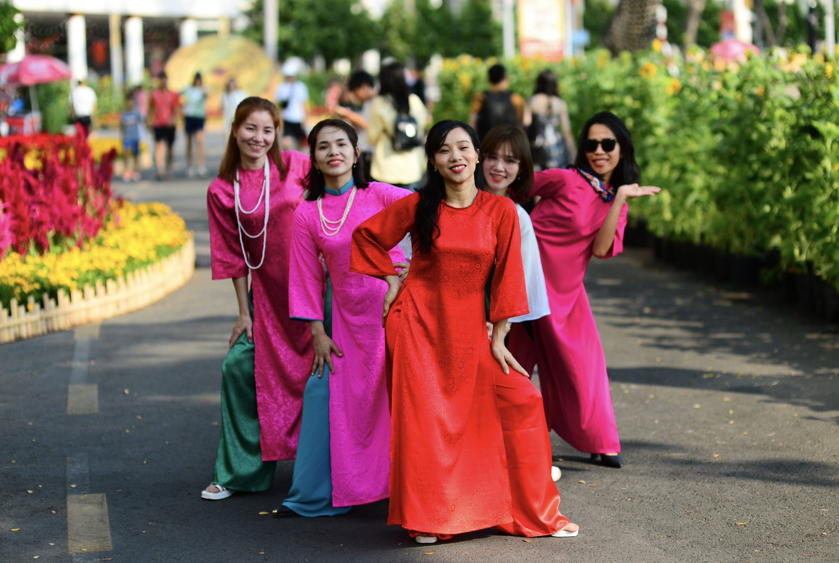 Young women in ao dai pose for a photo on Phu My Hung Flower Street, which opened to the public in Ho Chi Minh City on February 3, 2024. Photo: Quang Dinh / Tuoi Tre