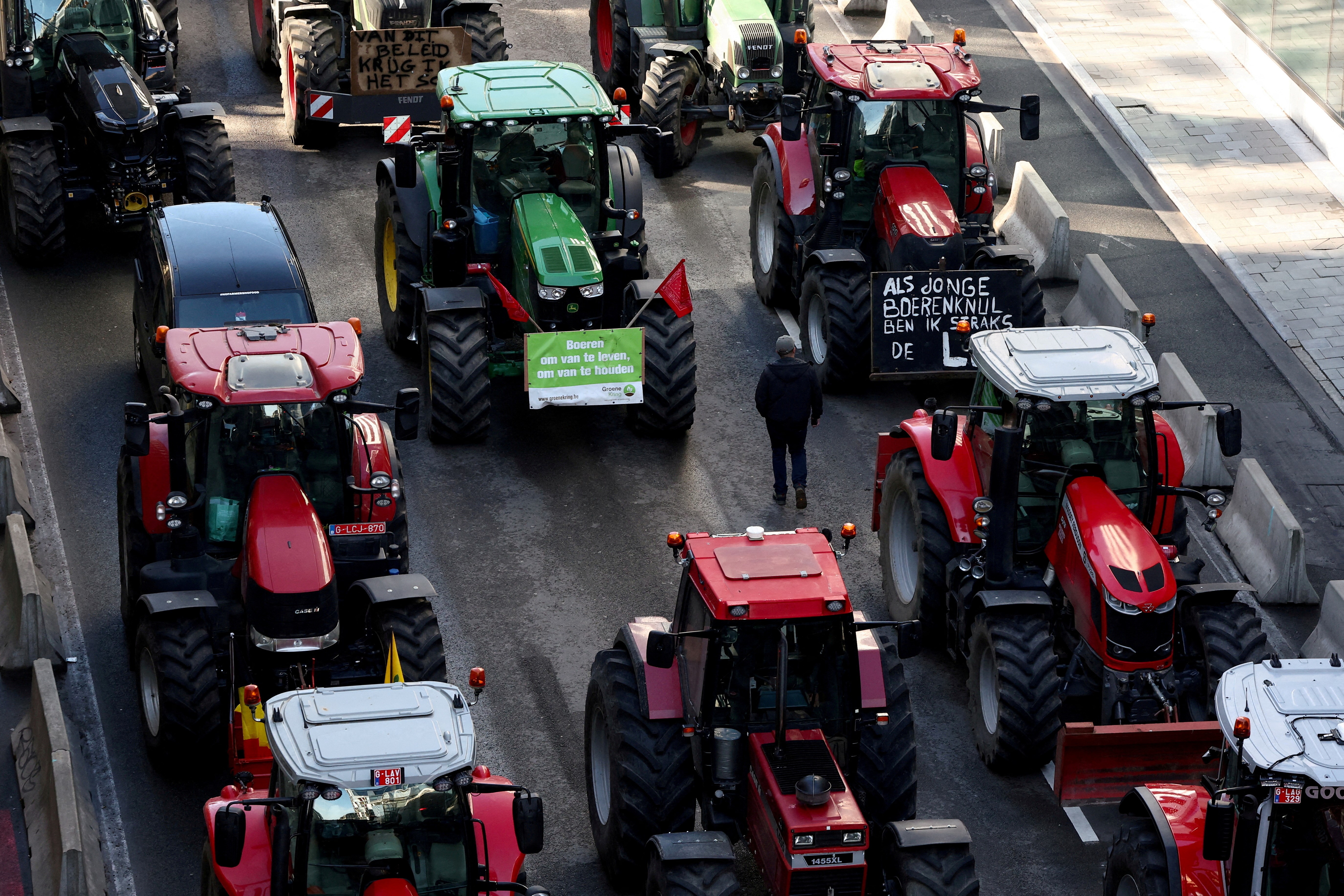 A man walks among tractors as farmers from Belgium and other European countries block a road near the European Parliament during a protest over price pressures, taxes and green regulation, on the day of an EU summit in Brussels, Belgium February 1, 2024. Photo: Reuters