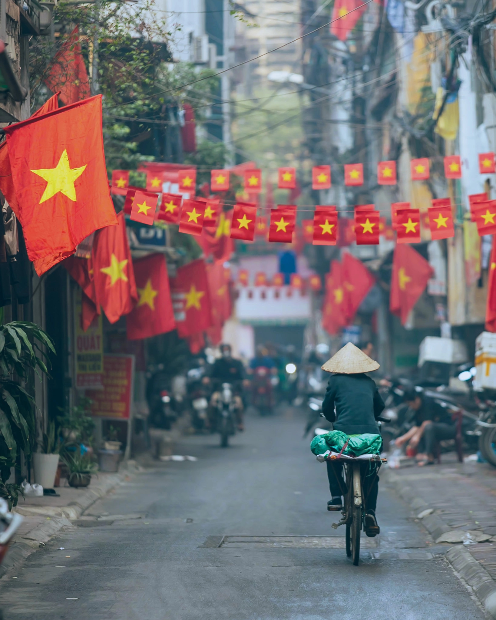 A woman rides a bicycle on a street festooned with Vietnamese national flags in Hanoi. Photo: Lee Hyo-seung