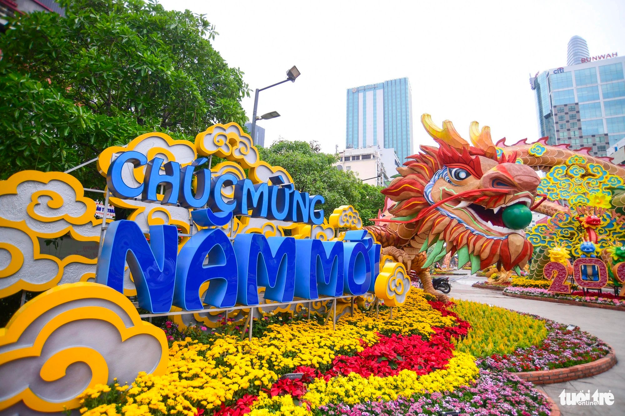 A statue of dragon is placed next to a message that reads 'Happy New Year' in Vietnamese at the 2024 Nguyen Hue Flower Street in District 1, Ho Chi Minh City. Photo: Quang Dinh / Tuoi Tre