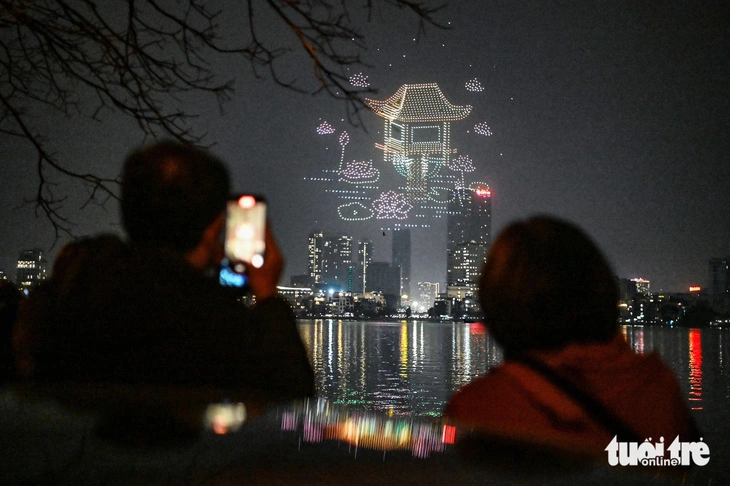 Mot Cot (One-Pillar) Pagoda, a renowned attraction in Hanoi, is artistically illuminated by colorful drones, creating a mesmerizing display in the night sky of the Vietnamese capital on February 9, 2024. Photo: Hong Quang / Tuoi Tre