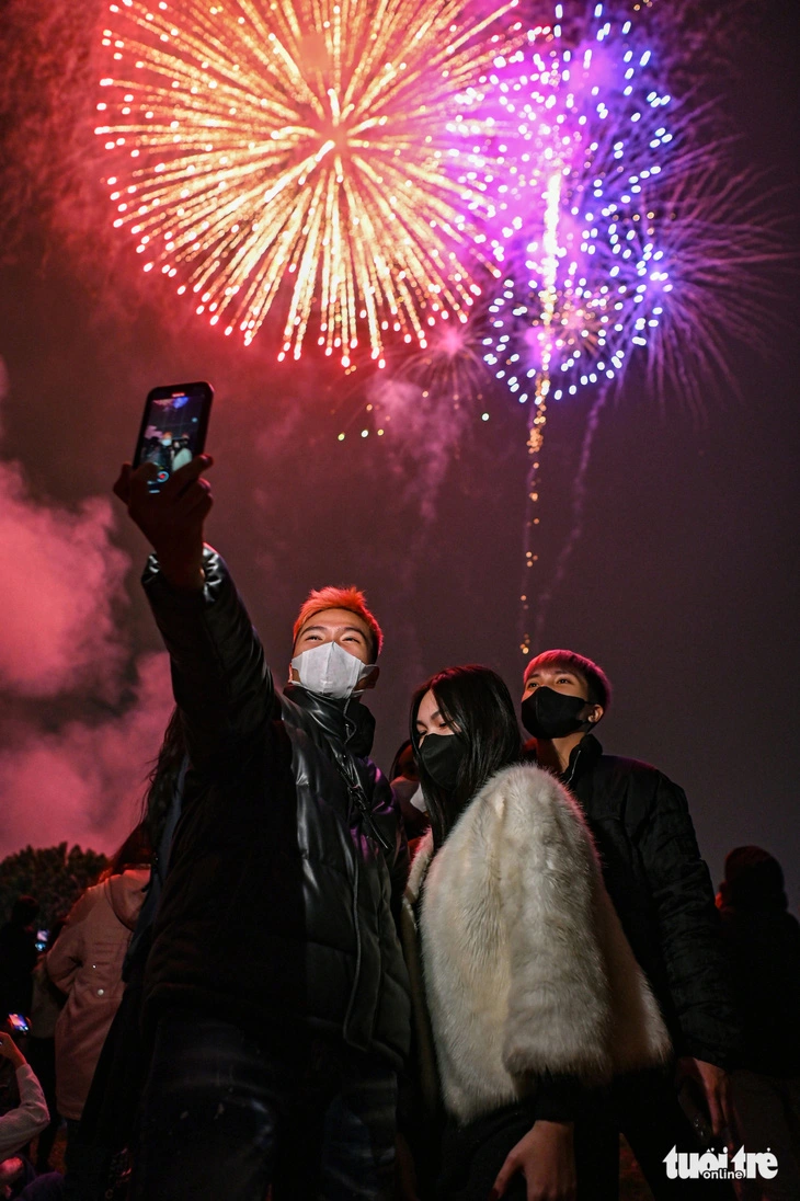 Young individuals in Hanoi record scenes of the fireworks displays held in celebration of the Lunar New Year festival at West Lake on February 9, 2024. Photo: Hong Quang / Tuoi Tre