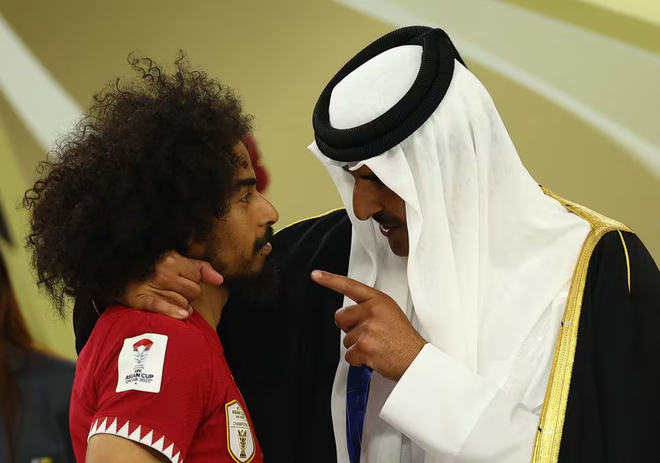 Soccer Football - AFC Asian Cup - Final - Jordan v Qatar - Lusail Stadium, Lusail, Qatar - February 10, 2024 Qatar's Akram Afif with Qatar's Emir, Sheikh Tamim bin Hamad al-Thani after winning the AFC Asian Cup. Photo: Reuters
