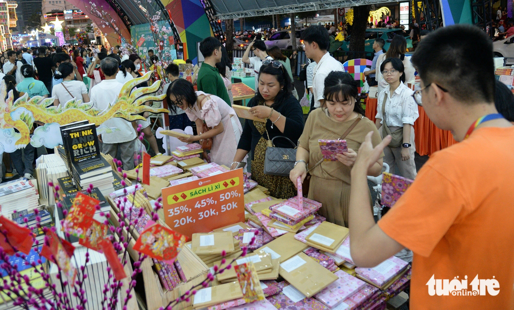 Revelers gather at a booth giving away books as Tet gifts. Photo: Tu Trung / Tuoi Tre