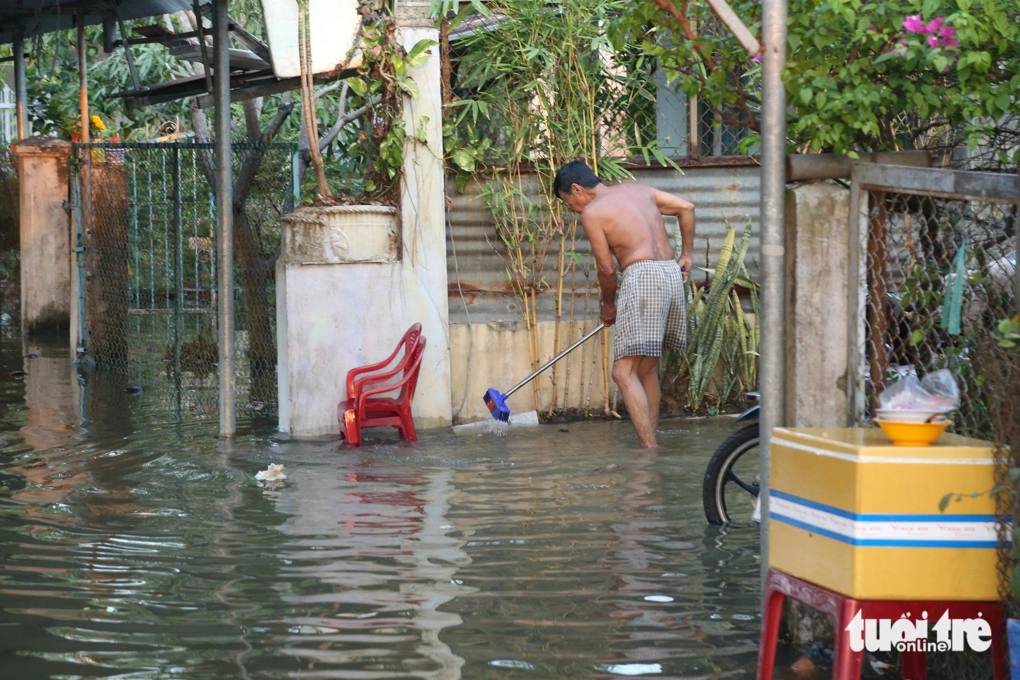 A man is seen removing trash from a manhole to let flood water drain away quickly.  Photo: Hoai Thuong / Tuoi Tre