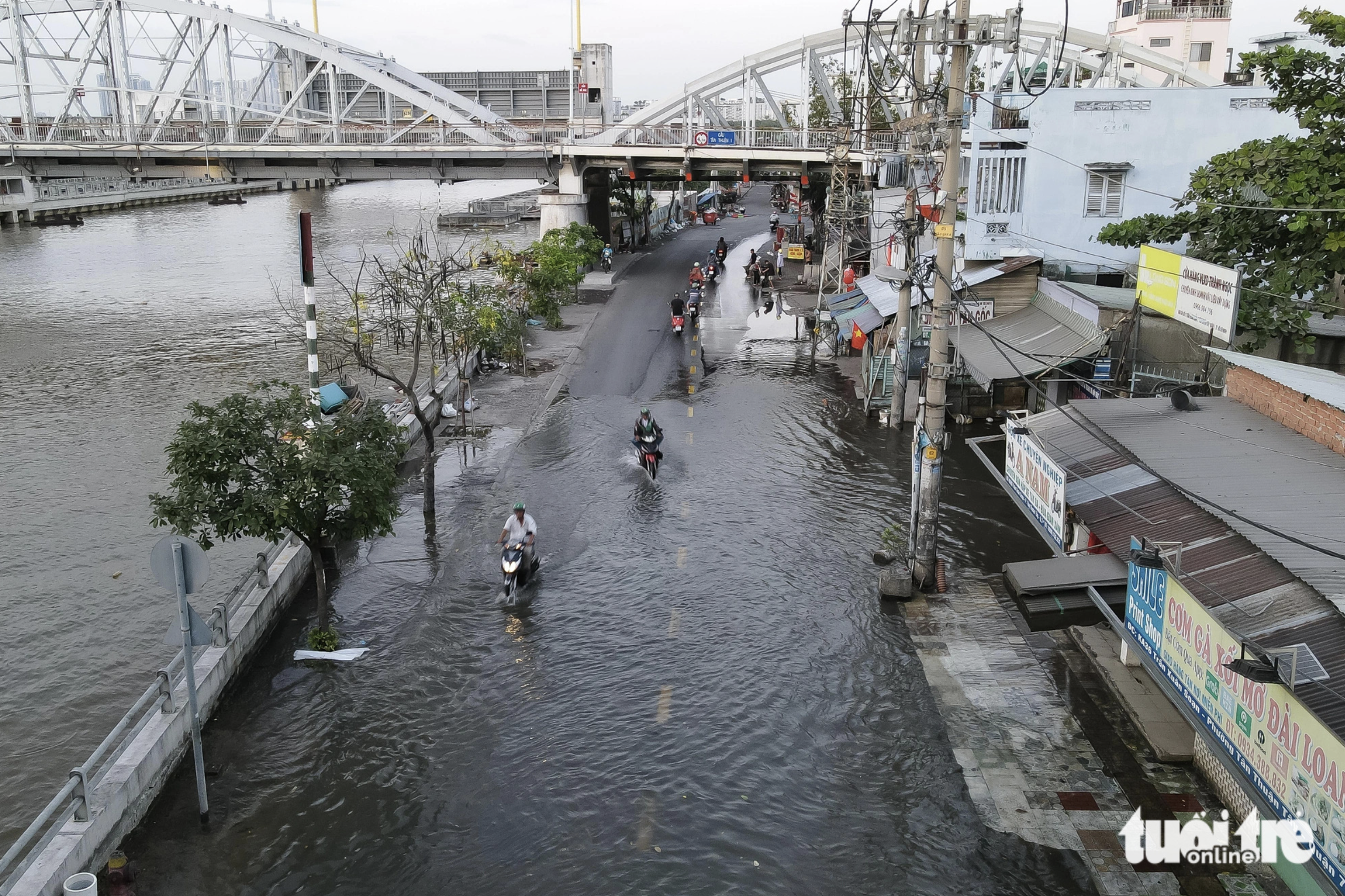 Residents commute on a flooded street in District 7, Ho Chi Minh City. Photo: Tuoi Tre