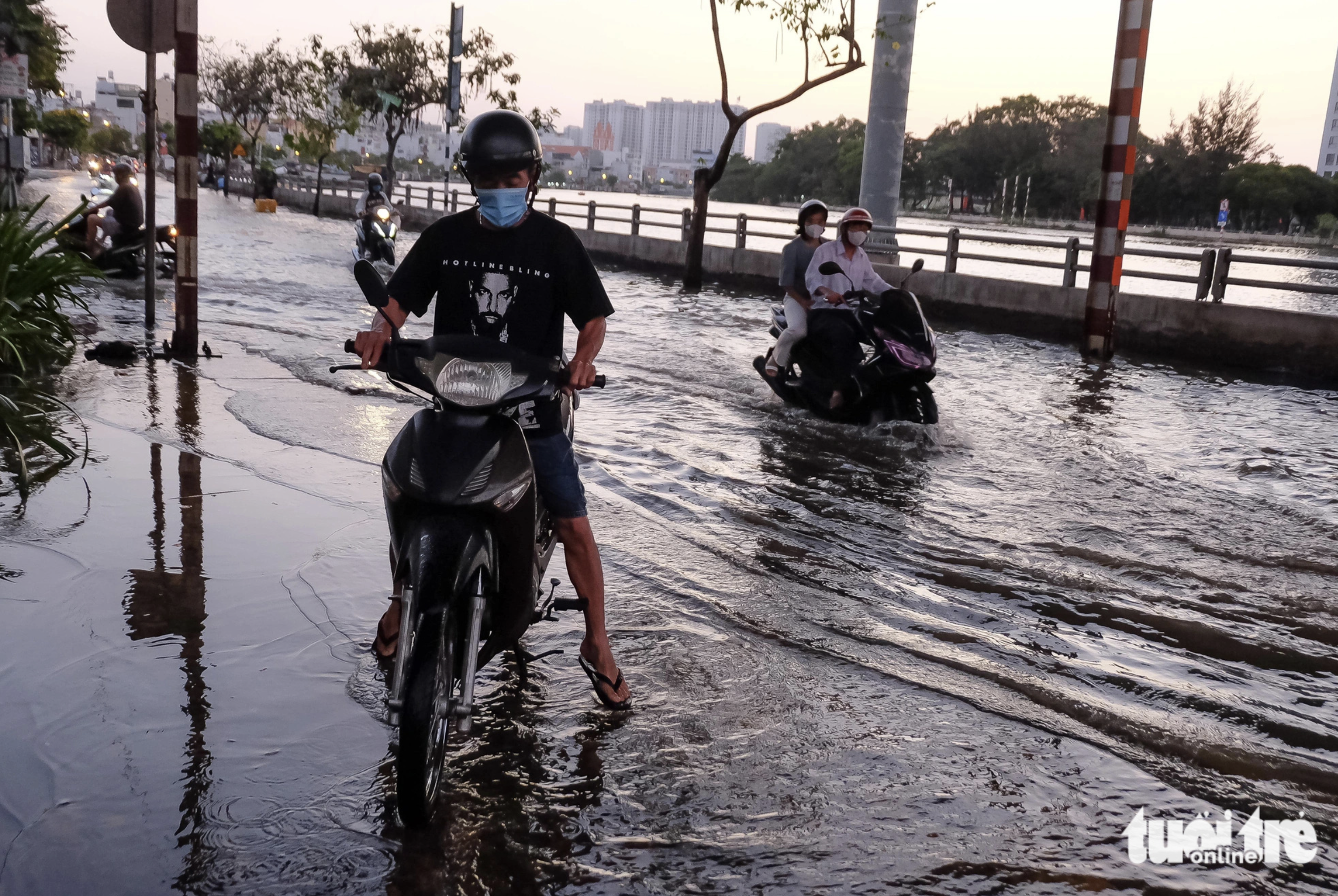 Nam’s motorcycle broke down while he was traveling on a flooded street in District 7, Ho Chi Minh City, caused by high tide. Photo: Tuoi Tre