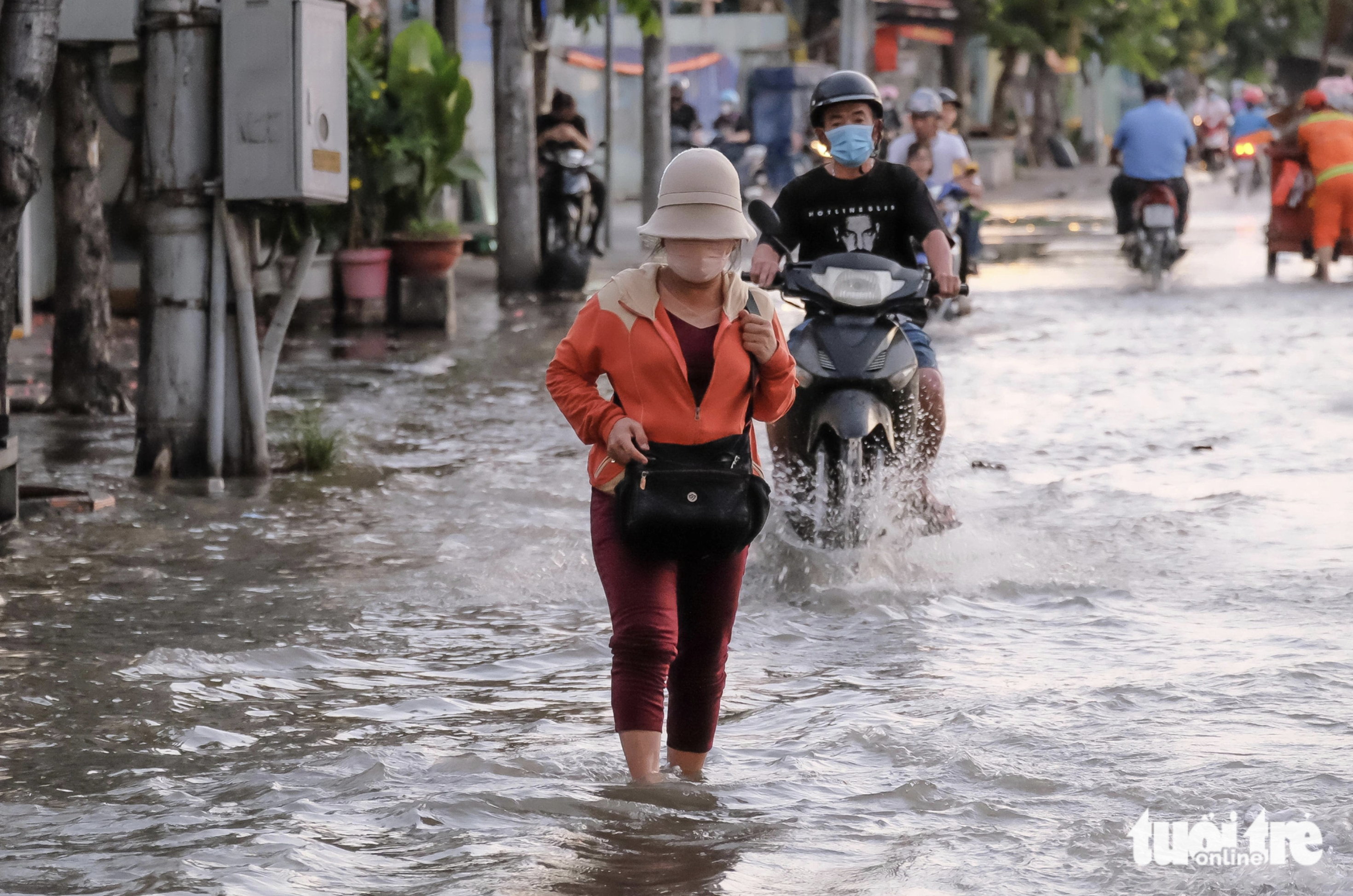 A woman walks on an inundated street in Ho Chi Minh City. Photo: Tuoi Tre