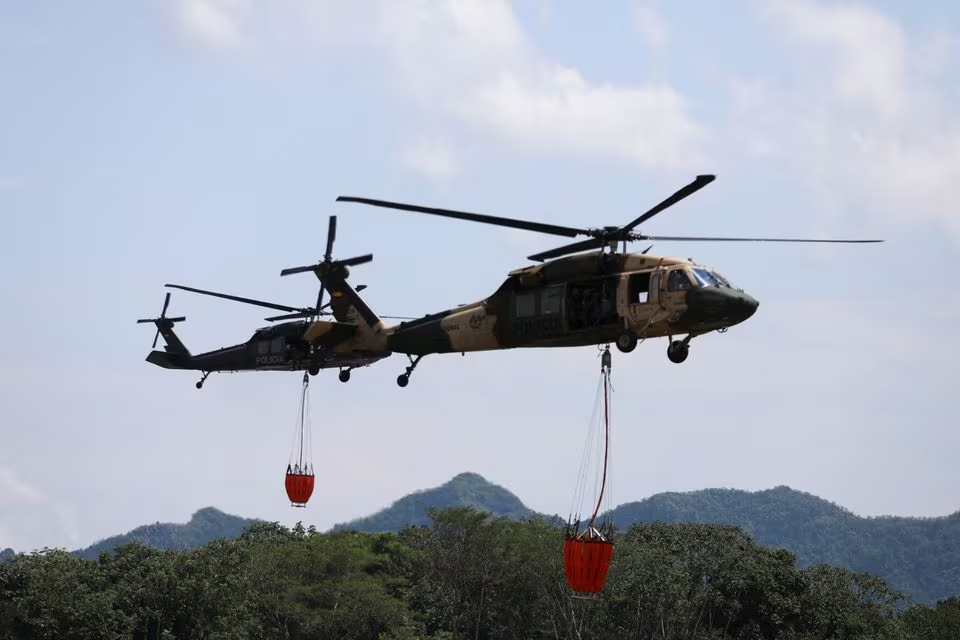 UH-60 Black Hawk helicopters donated by the United States to the Colombian Police fly over with the Bambi Bucket system to extinguish fires during a demonstration to the press, at the Police Aviation School in Mariquita, Colombia February 14, 2024. Photo: Reuters