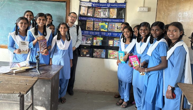Nguyen Quang Thach (wearing glasses) and Indian students pose for a photo next to a bookshelf. Photo: Supplied