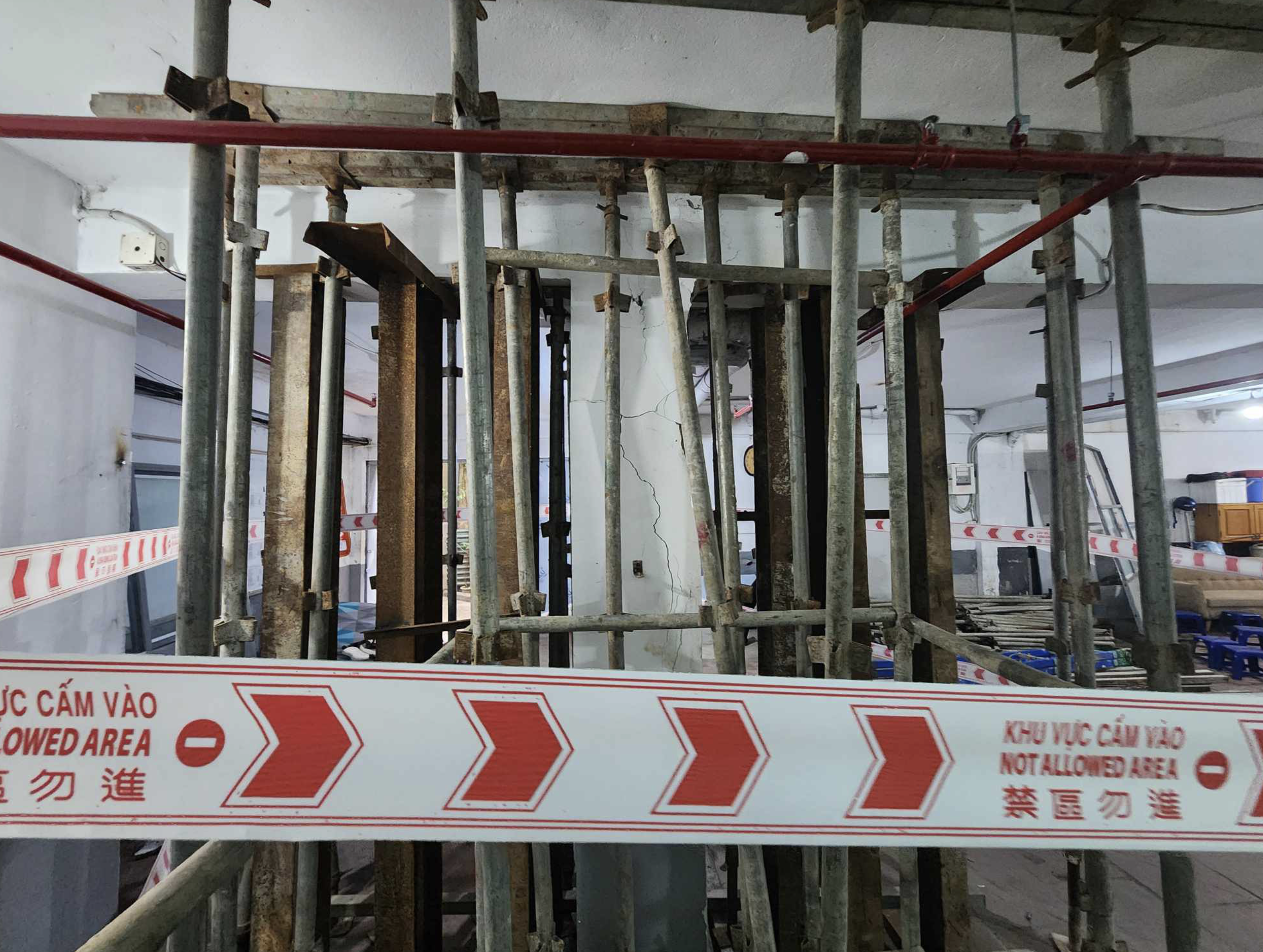 Scaffolding poles are erected to support a deteriorated pillar on the ground floor of an apartment building in Hanoi. Photo: Quang Vien / Tuoi Tre