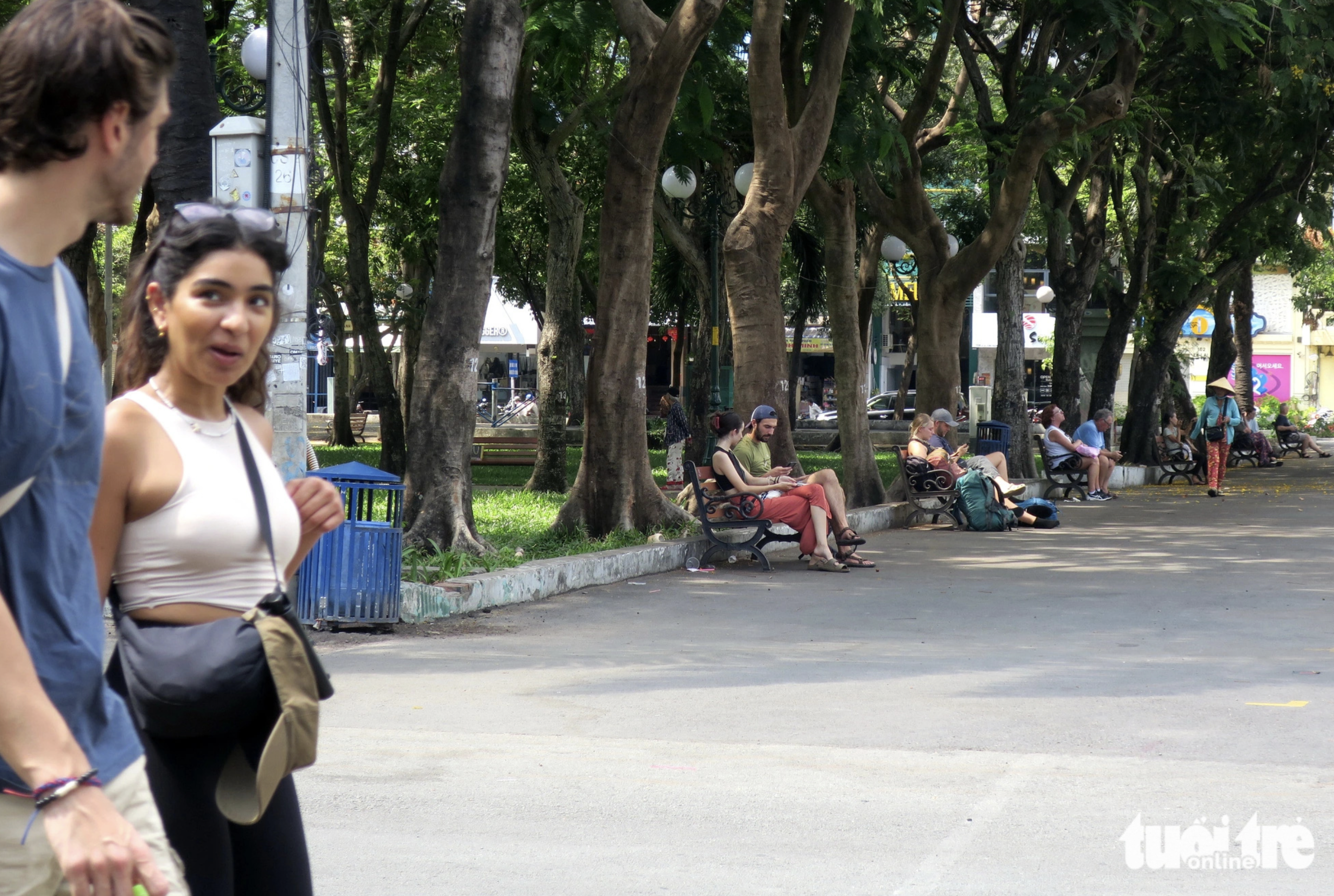 Tourists sit down in the shade of trees at September 23 Park in downtown Ho Chi Minh City. Photo: T.T.D. / Tuoi Tre