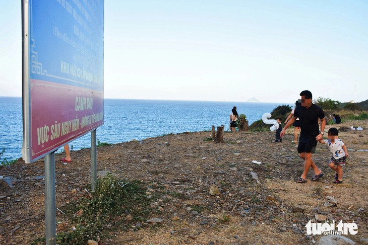 Tourists admire landscapes in an area where a warning sign is erected. Photo: Tran Hoai / Tuoi Tre