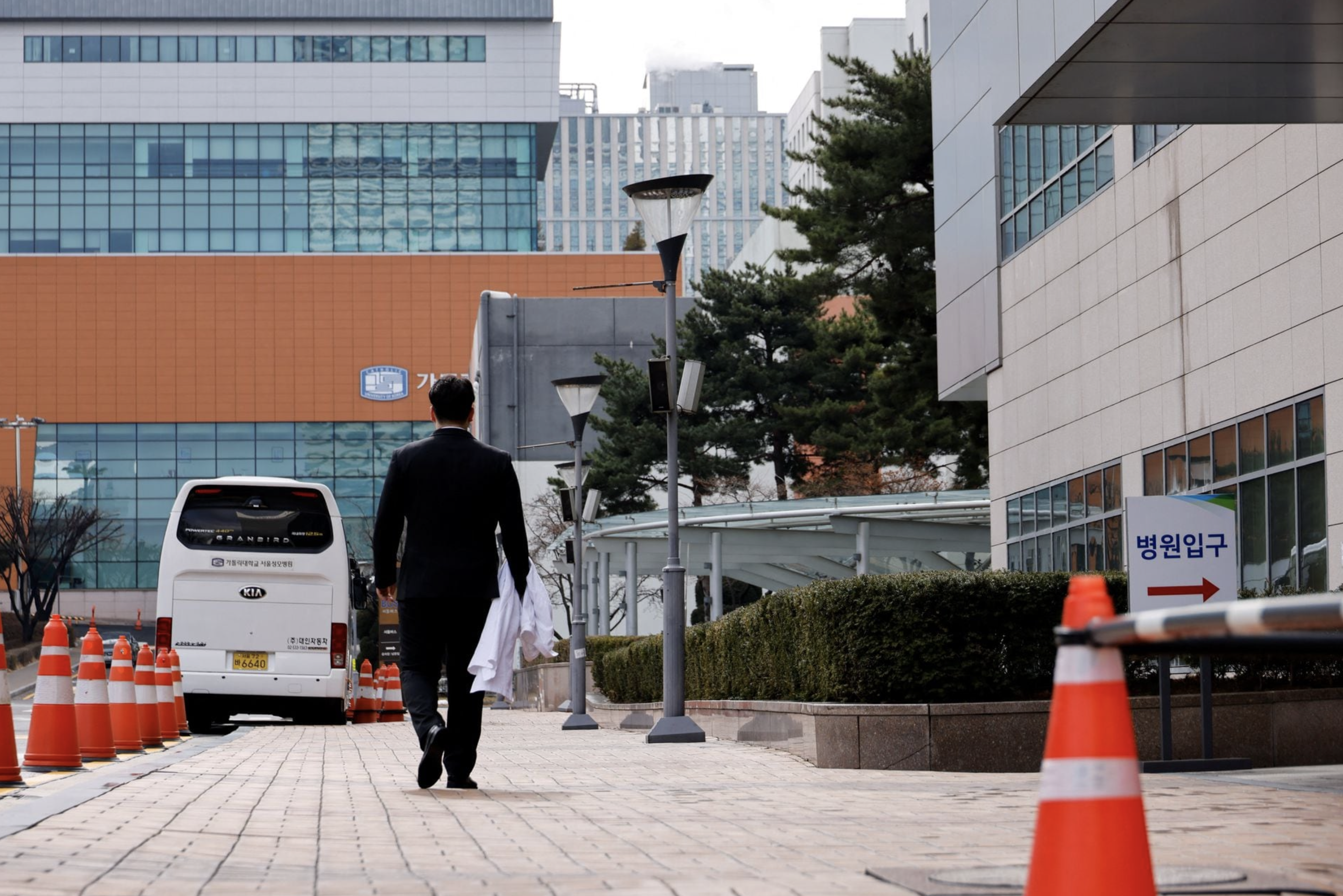 Ryu O. Hada, 25, one of the thousands of South Korean trainee doctors who resigned en masse to protest the government's medical policy, holds his white coat in front of the hospital where he worked in Seoul, South Korea, February 25, 2024. Photo: Reuters