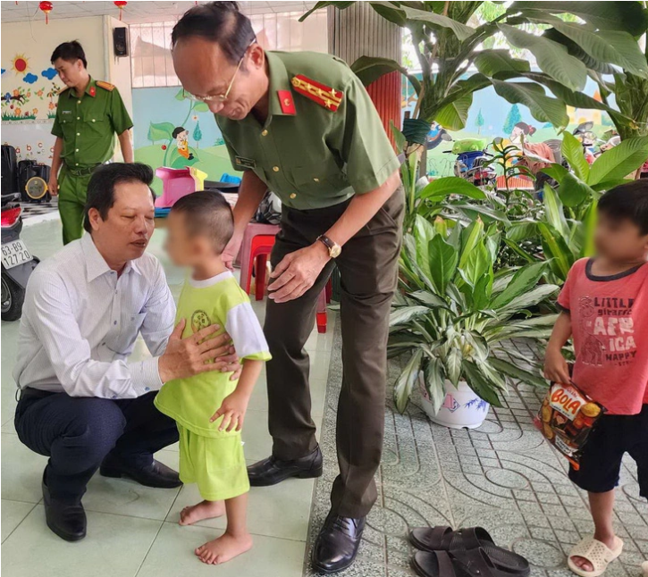 Vice-chairman of the Tien Giang government Nguyen Thanh Dieu (in a white shirt) and Colonel Nguyen Van Nhut, director of the provincial Department of Public Security, encourage a child after the case. Photo: Hoai Thuong / Tuoi Tre