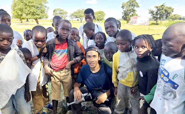 Lai Ngua Chan poses for a photo with children in Angola. Photo: Supplied