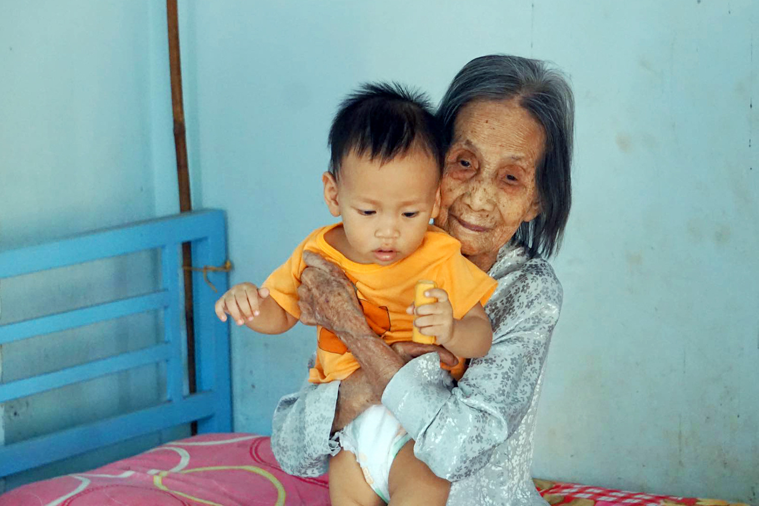 Trinh Thi Khong holds her descendant. Photo: Binh An / Tuoi Tre