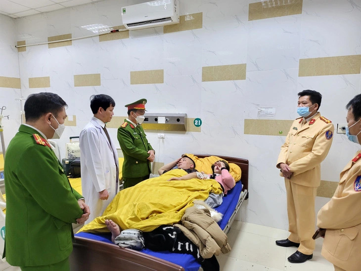 Two out of the ten injured victims of the deadly accident between a sleeper bus and a container truck in Tuyen Quang Province are seen being visited by police officers at Phuong Bac General Hospital in the province’s Tuyen Quang City. Photo: VNA