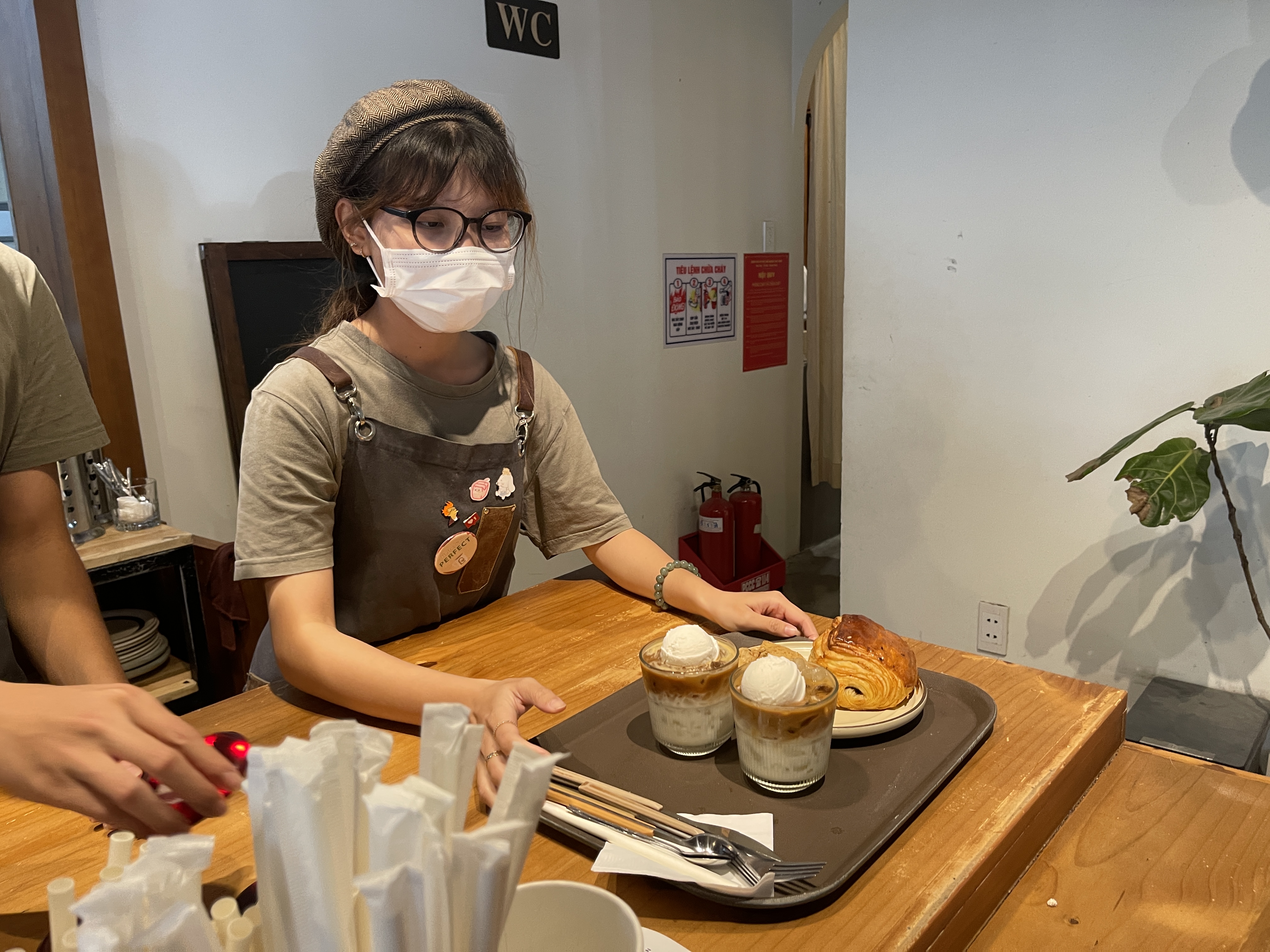 A staff memeber serves beverages and cakes to customers at a coffee shop in Tan Phu District, Ho Chi Minh City. Photo: Dong Nguyen / Tuoi Tre News