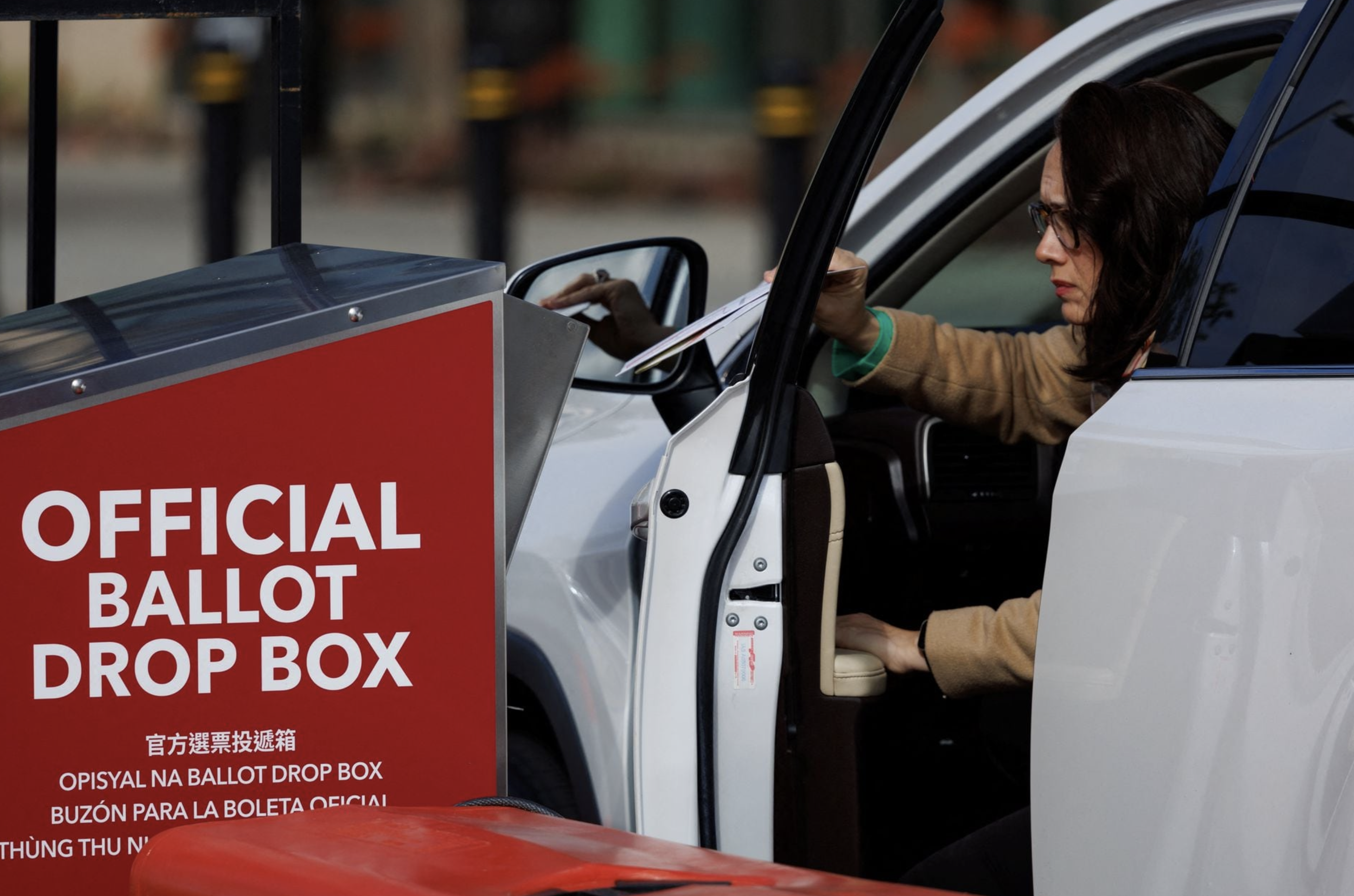 A voter drops a ballot paper into a drop box from her vehicle during the Super Tuesday primary election in San Diego, California U.S., March 5, 2024. Photo: Reuters