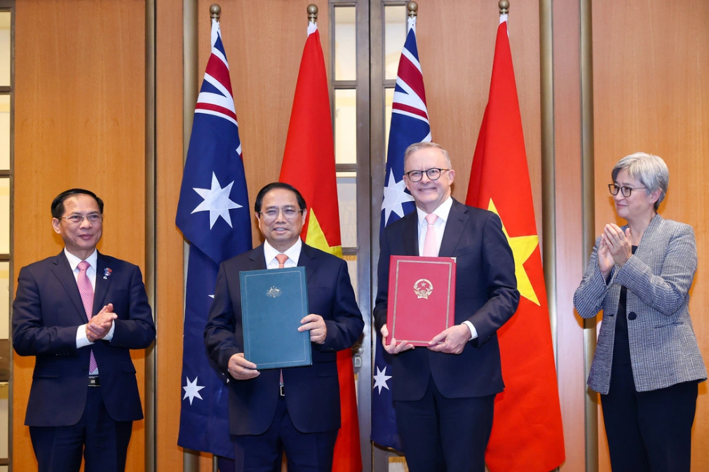 Vietnamese Prime Minister Pham Minh Chinh (L, 2nd) and his Australian counterpart Anthony Albanese (R, 2nd) exchange the joint statement on the elevation of the two countries’ relations to a comprehensive strategic partnership. Photo: Vietnam Government Portal