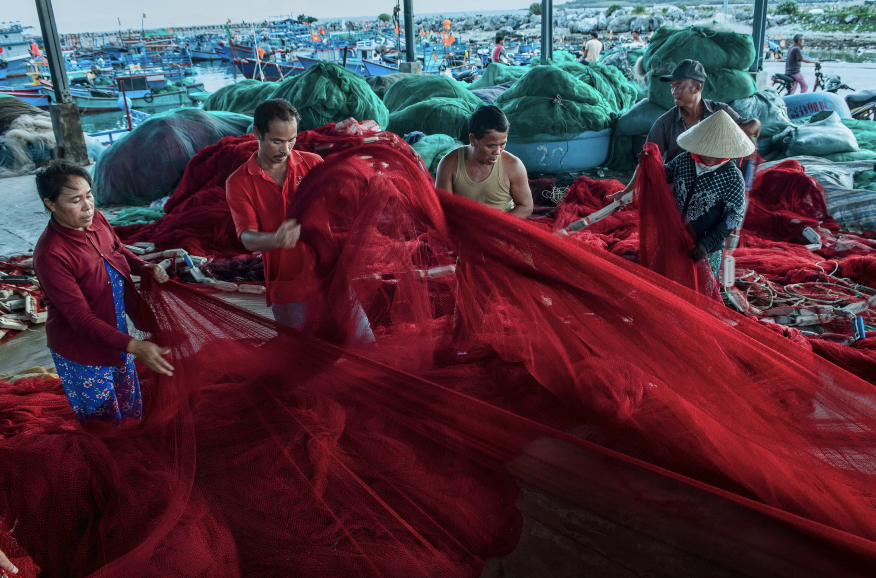 Net weavers are pictured checking a net before it is pulled back to a boat for the next fishing trip at My Tan Fishing Port in Ninh Thuan Province, south-central Vietnam Photo: Ly Hoang Long / Tuoi Tre