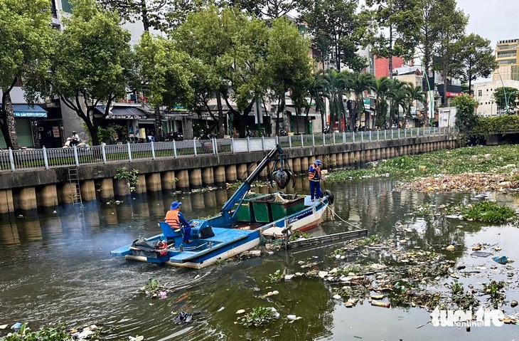 Workers resume the collection of garbage on the canal on March 10, 2024. Photo: Chau Tuan / Tuoi Tre