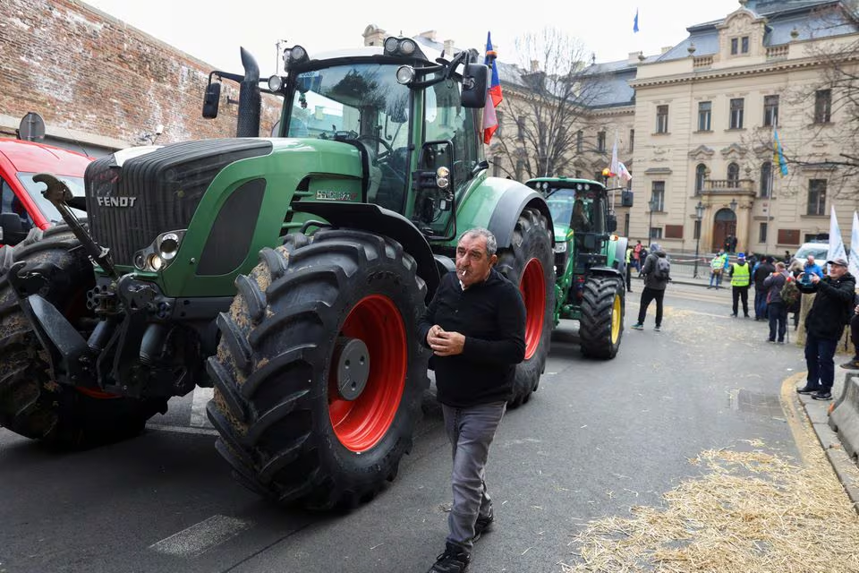A driver smokes as he walks past his tractor parked in front of a government office in Prague, Czech Republic, March 7, 2024. Photo: Reuters
