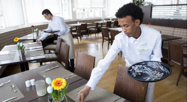 Migrant workers at a restaurant in Germany. Photo: DW