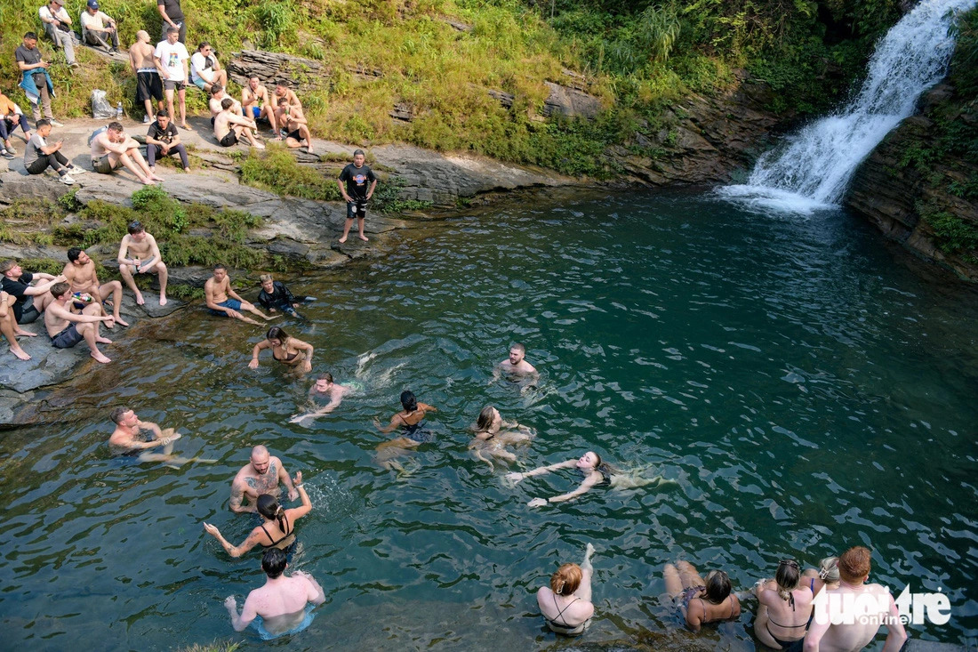 This image shows travelers, most of them foreigners, enjoying bathing and swimming at the Du Gia waterfall area in Ha Giang Province, northern Vietnam. Photo: Nam Tran / Tuoi Tre