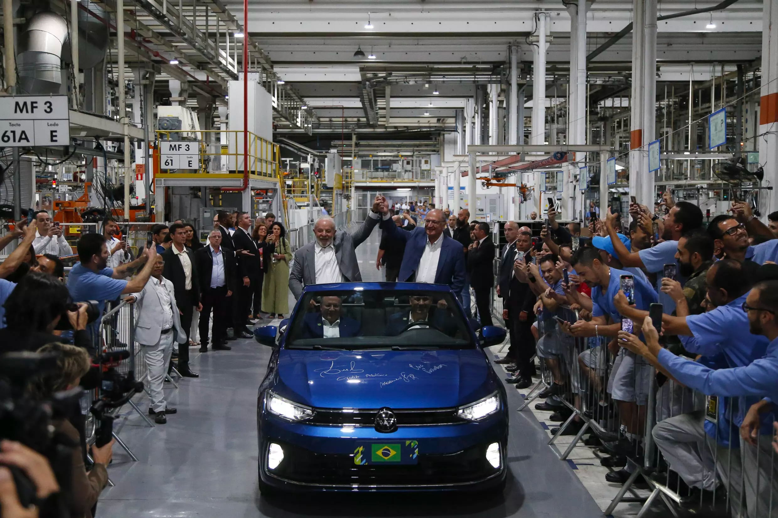 Brazilian President Luiz Inacio Lula da Silva (L) and his vice-president, Geraldo Alckmin, greet workers as they visit the Volkswagen car factory  Miguel SCHINCARIOL / AFP/File