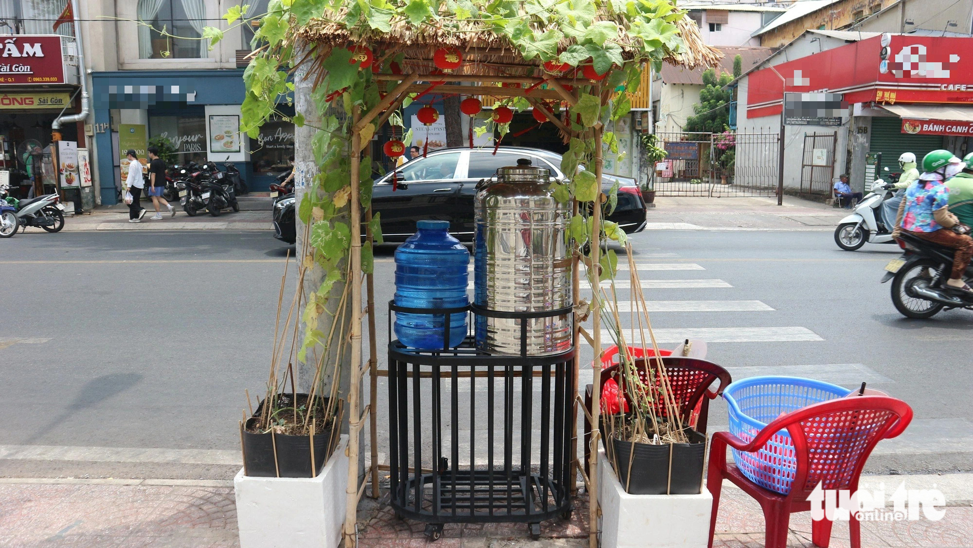 Vine-shaded charity water tanks highlight Saigonese generosity