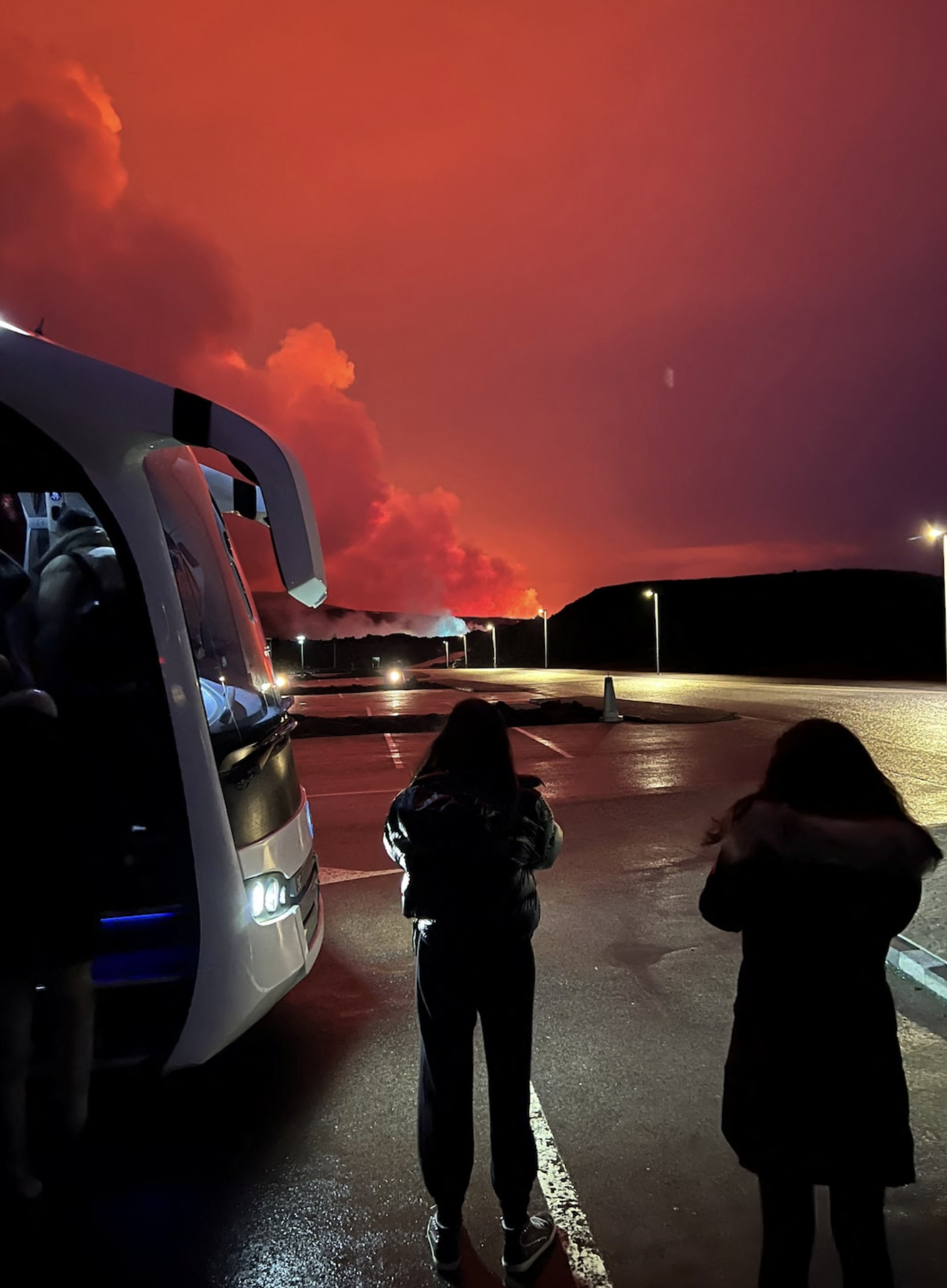 People who are being evacuated stand by a bus as a volcano erupts, in Grindavik, Iceland, March 16, 2024. Photo: Reuters