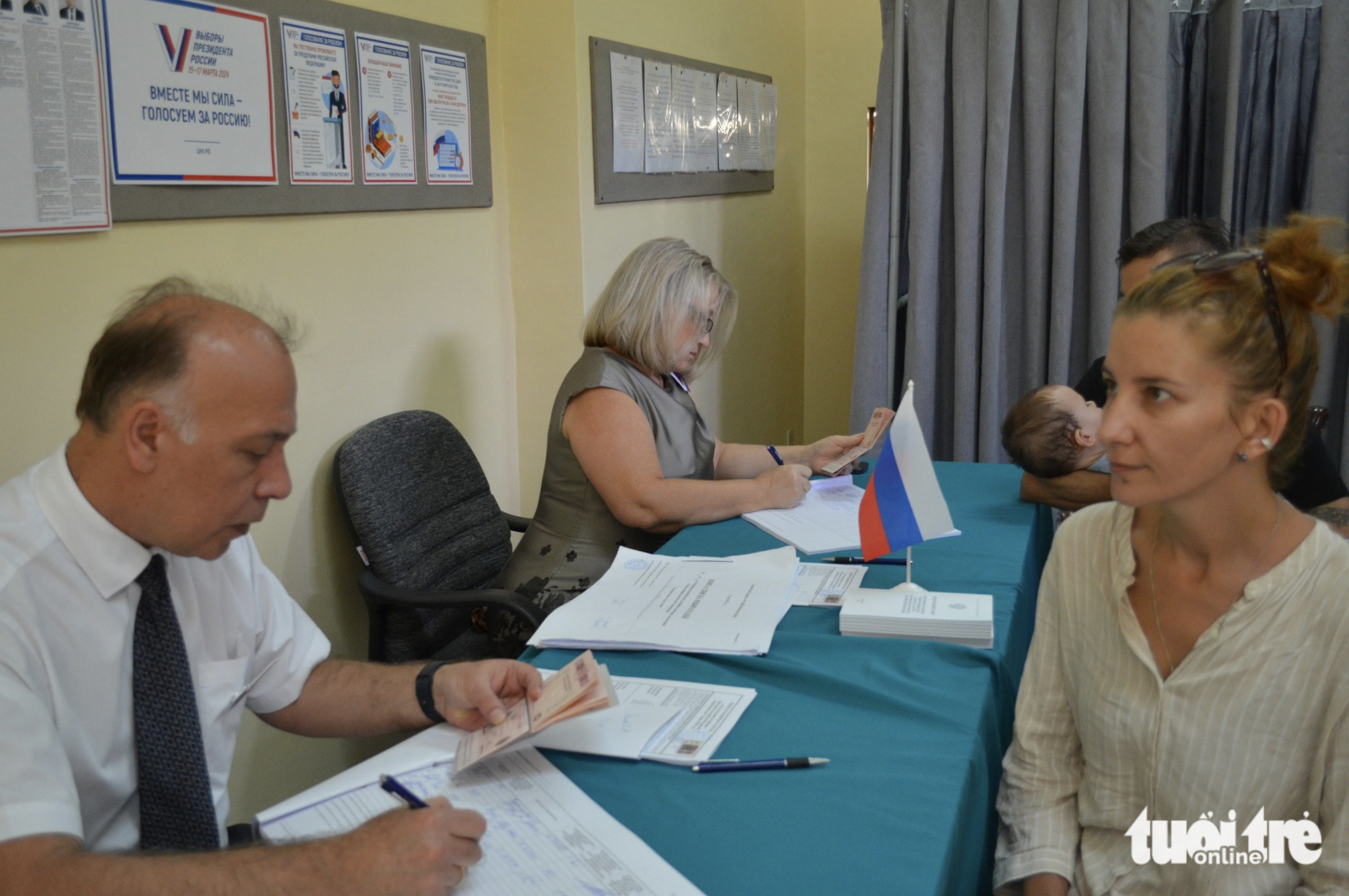 Elena (R) and her husband are pictured at a polling room at the Consulate General of Russia in Ho Chi Minh City. Photo: Uyen Phuong / Tuoi Tre