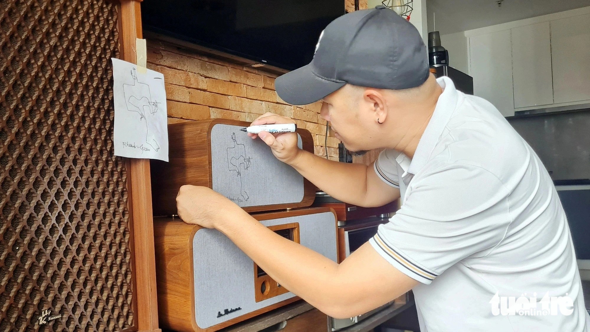 Architect Lam Thanh Tung adds a personal touch by drawing on the speaker grilles of each music player. Photo: M.V. / Tuoi Tre