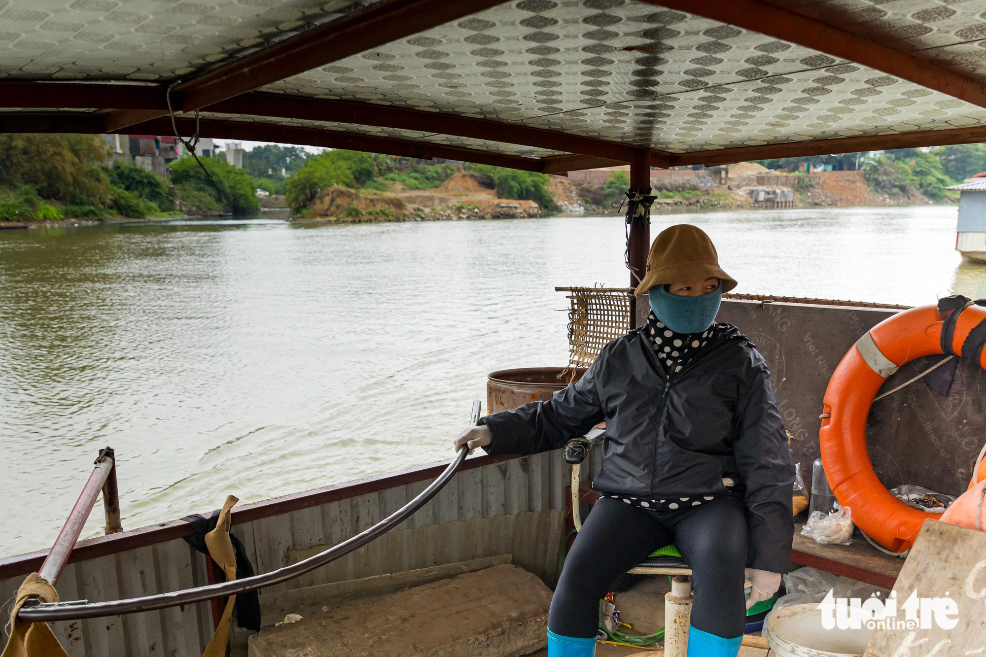 Hien, a boatwoman shuttling passengers between Bac Ninh City in Bac Ninh Province and Viet Yen Town in Bac Giang Province, northern Vietnam describe how the wastewater released into the Cau River emits a foul odor, sometimes causing discomfort to the nose. Photo: D.Khang / Tuoi Tre